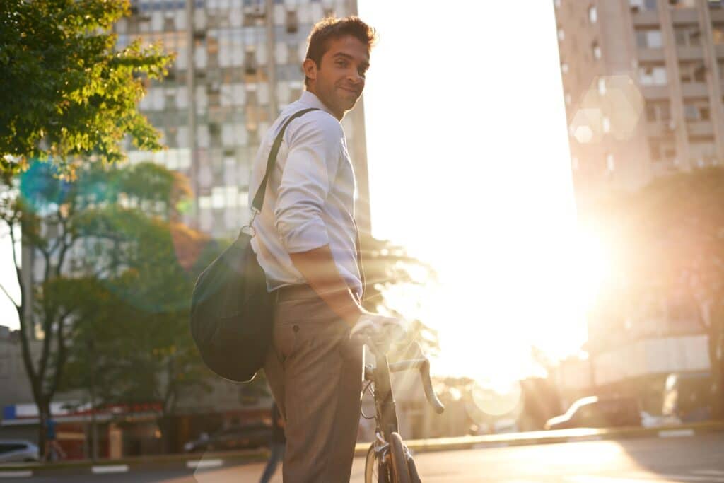 Shot of an attractive young man pushing his bicycle on the way to work